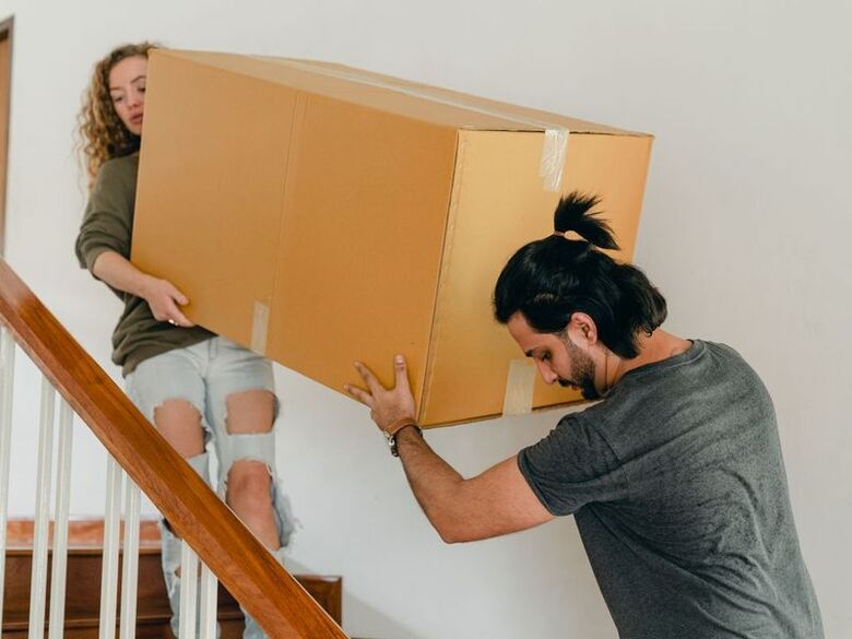 Smart Move crew carrying boxes up the front steps of a historic South End home on a narrow Portsmouth, NH lane